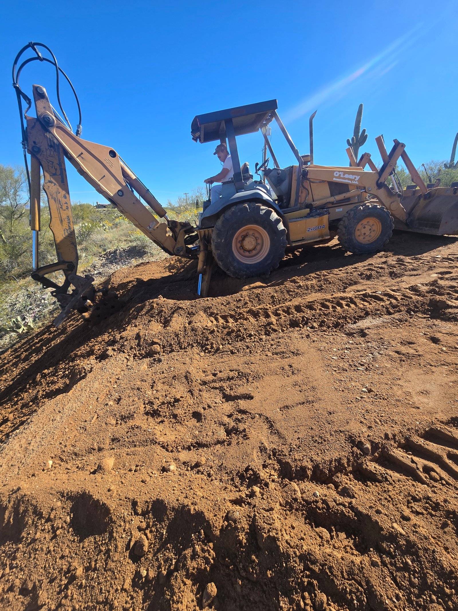 Backhoe finishing dirt slope